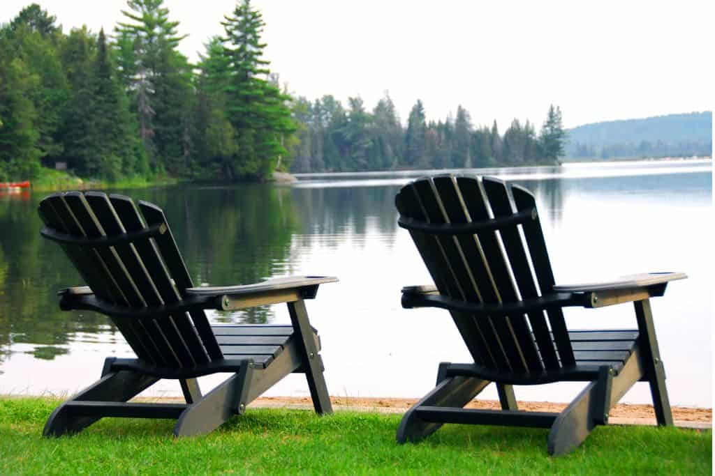 Chairs sitting by calm lake, a common site you will see at family friendly hotels in Muskoka